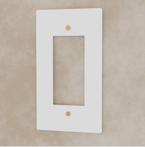 White wall plate with gold screws on a beige background