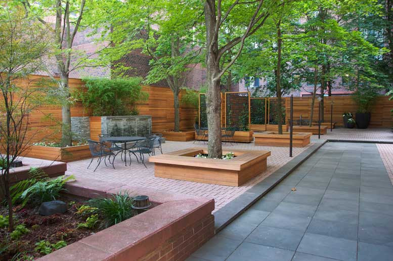 Custom outdoor planters with bluestone patio decking and stone waterfall created by TCSC