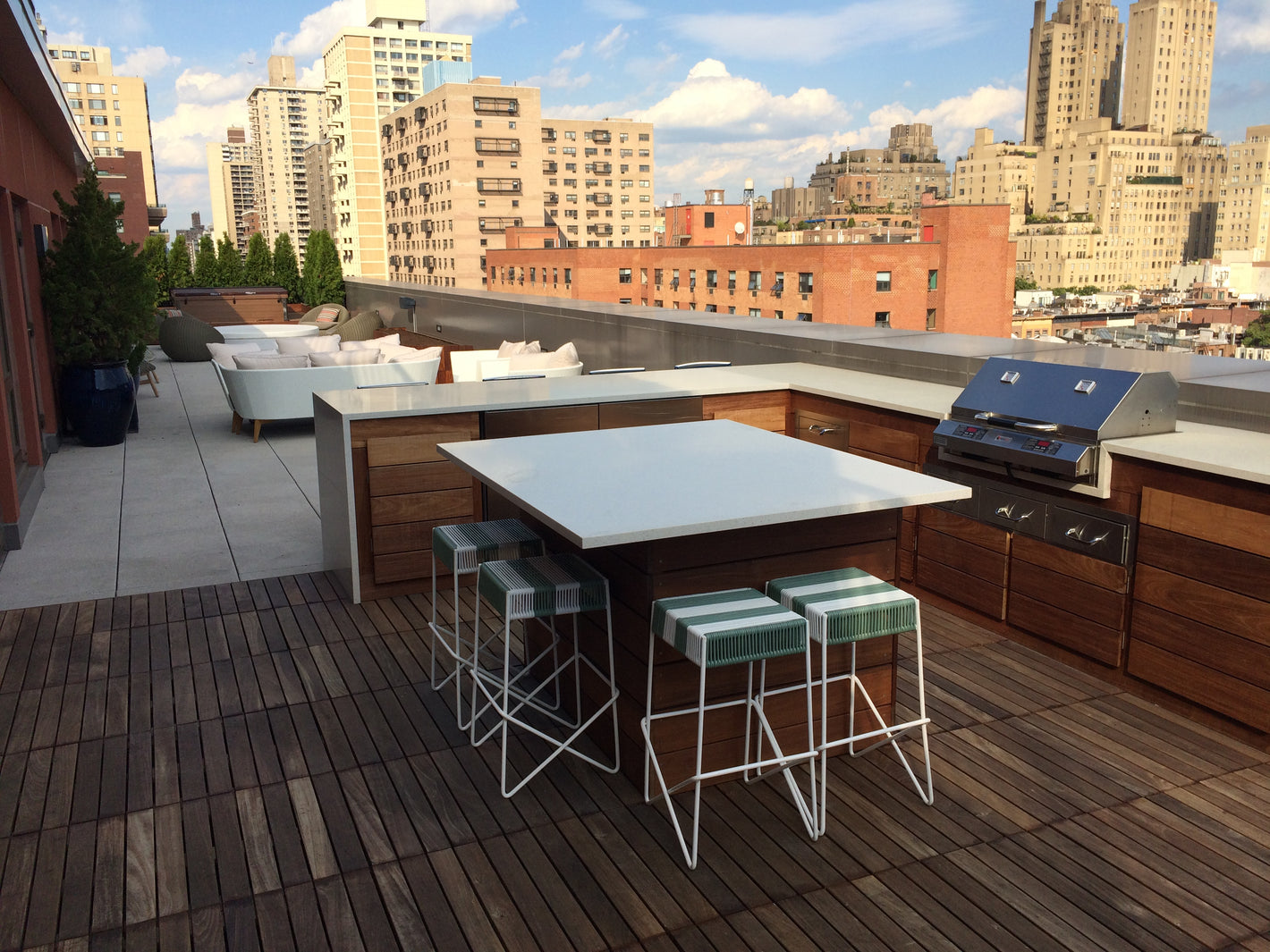 Custom rooftop kitchen with middle island and white granite countertop created by TCSC
