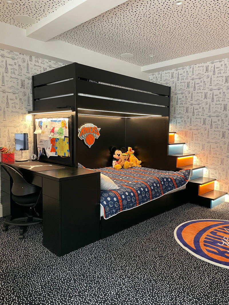 Black custom bunk bed with decorative items in a room with patterned walls.
