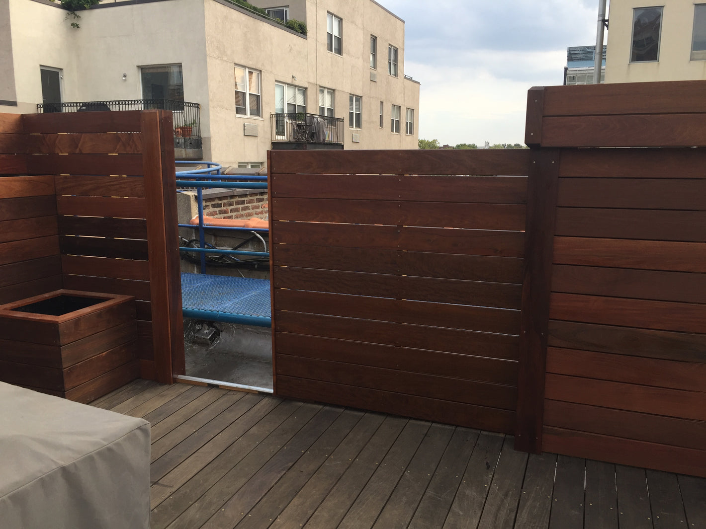 Rooftop custom fence with slide in and out door and planter box created by TCSC