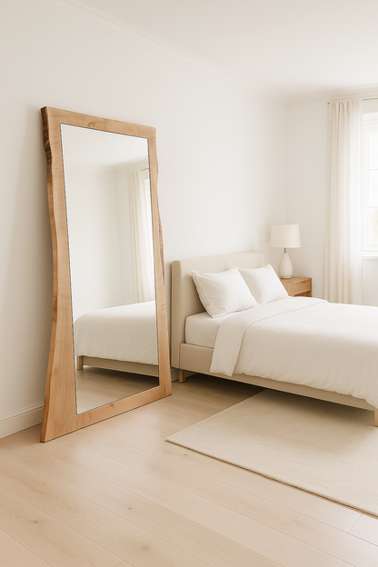 Wooden floor mirror in a bedroom with a bed and lamp.