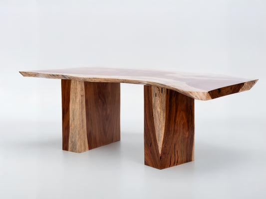 Wooden dining table with natural edge design on a white background