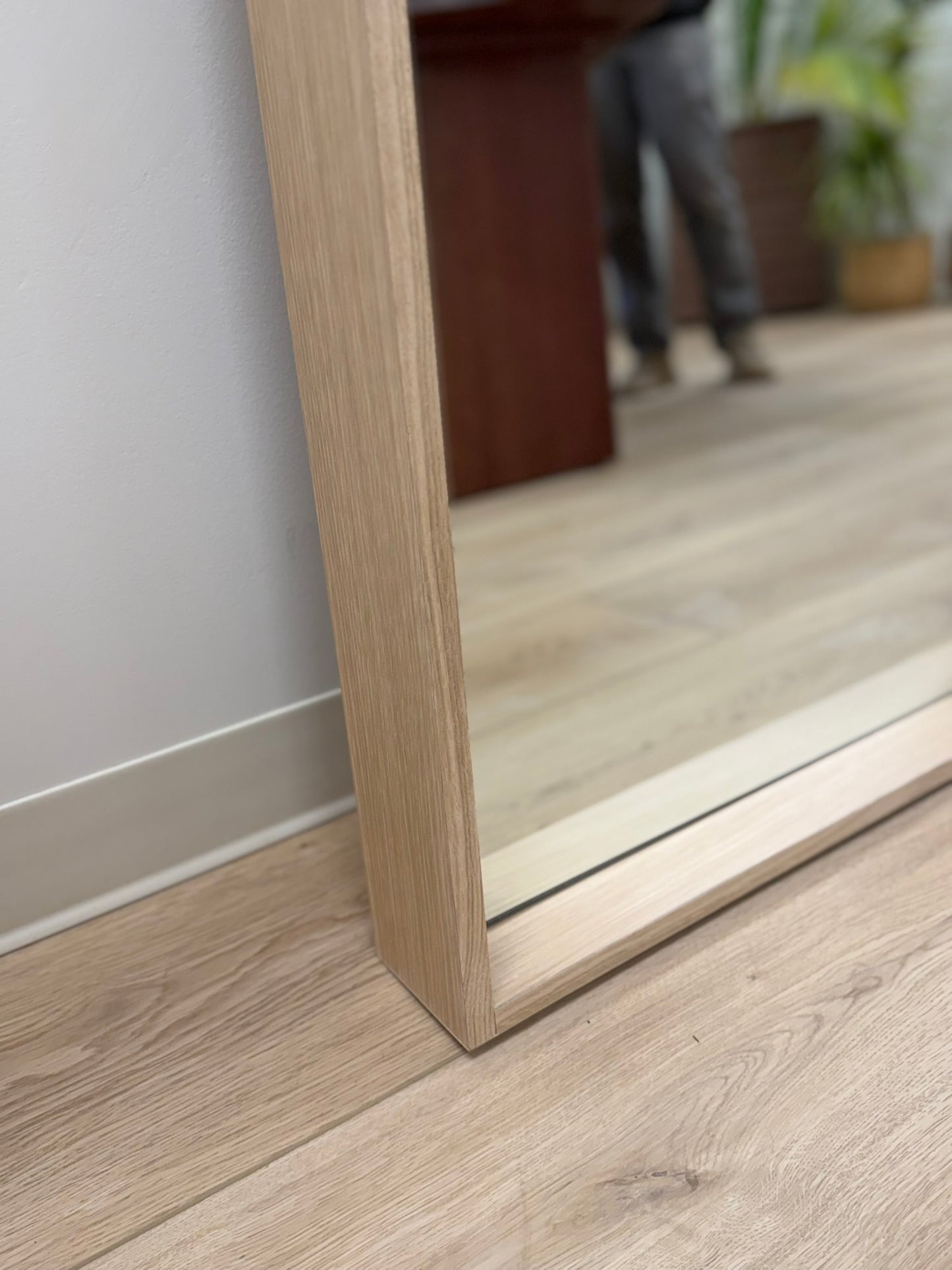 Wooden floor with a mirror reflecting a blurred indoor setting