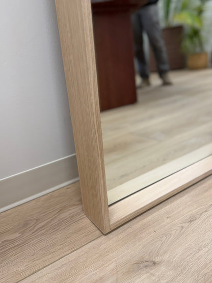 Wooden floor with a mirror reflecting a blurred indoor setting