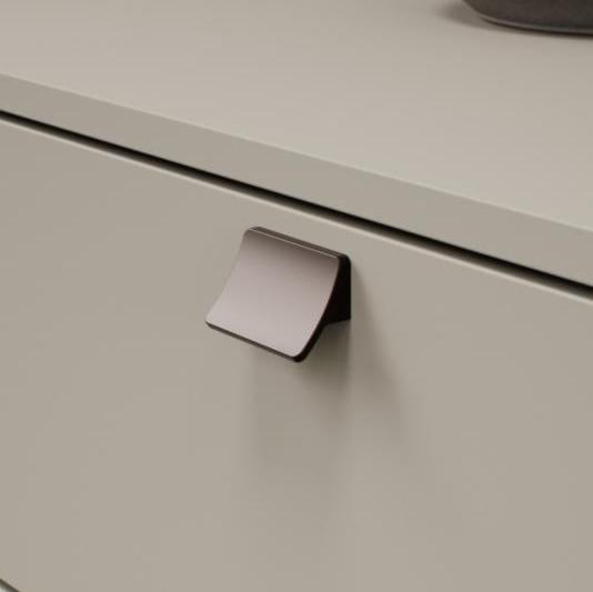 Metallic cabinet handle on a light gray cabinet door