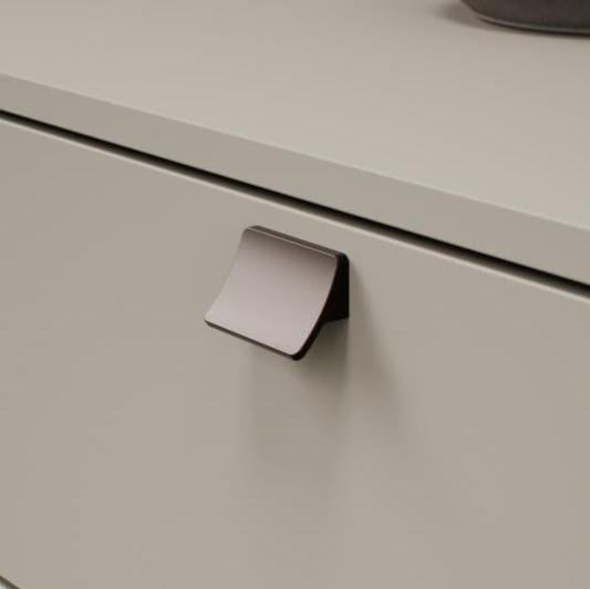 Metallic cabinet handle on a light gray cabinet door