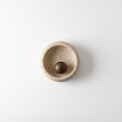 Ceramic wall lamp with a spherical object on a beige background